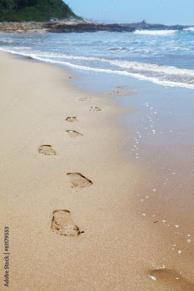 Human footprints on the beach sand leading towards the viewer Human footprints on the beach sand leading towards the viewer