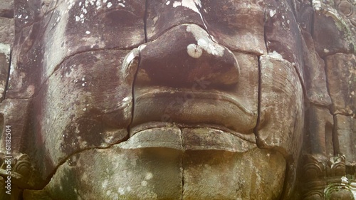 Stone face on the tower of the ancient temple. Bayon, Angkor, Ca