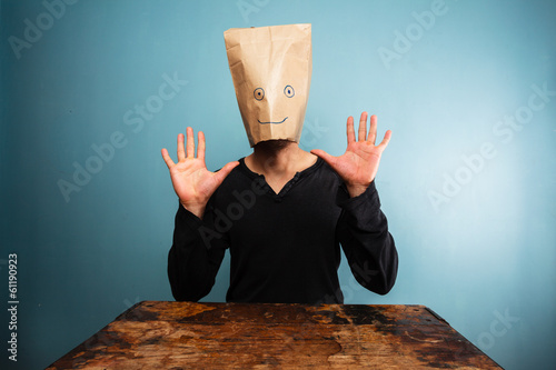 Stupid man with bag over his head and hands up