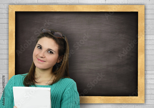 Ragazza con libro alla lavagna photo