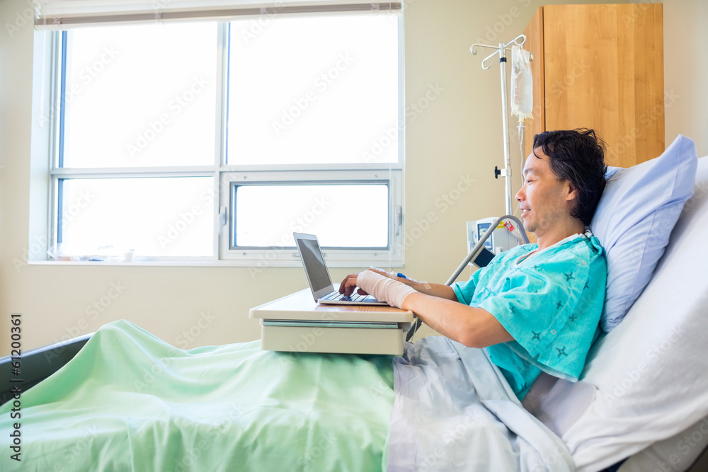 Fototapeta premium Patient Using Laptop On Hospital Bed