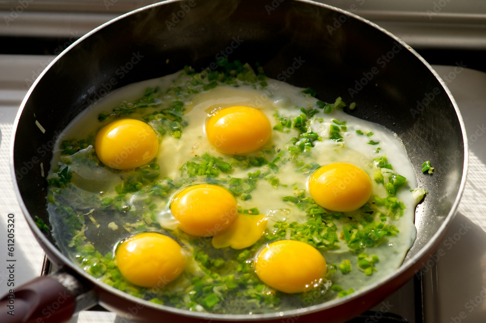 A freshly cooked eggs with herbs in a frying pan A freshly cooked eggs with herbs in a frying pan