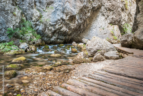 creek under rocks with wooden footpath photo