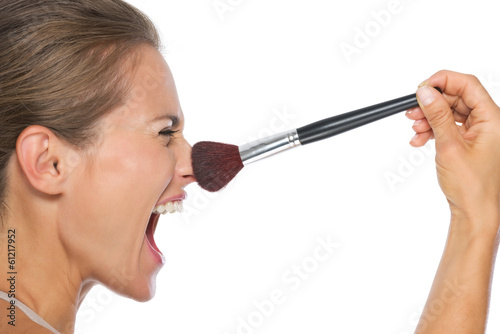 Profile portrait of young woman using brush