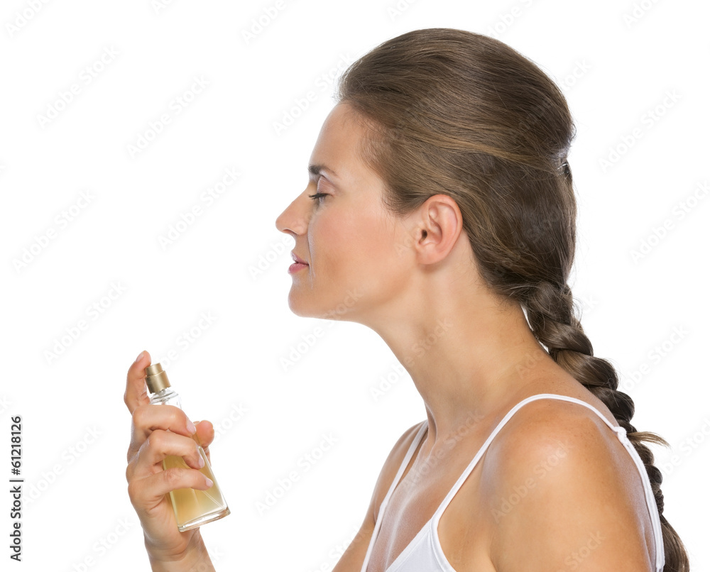 Profile portrait of young woman applying perfume Profile portrait of young woman applying perfume