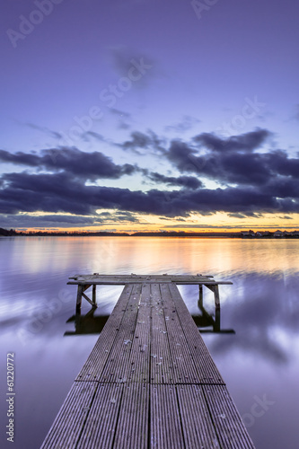 Fototapeta Purple Colored Sunset over Tranquil Lake with Wooden Jetty