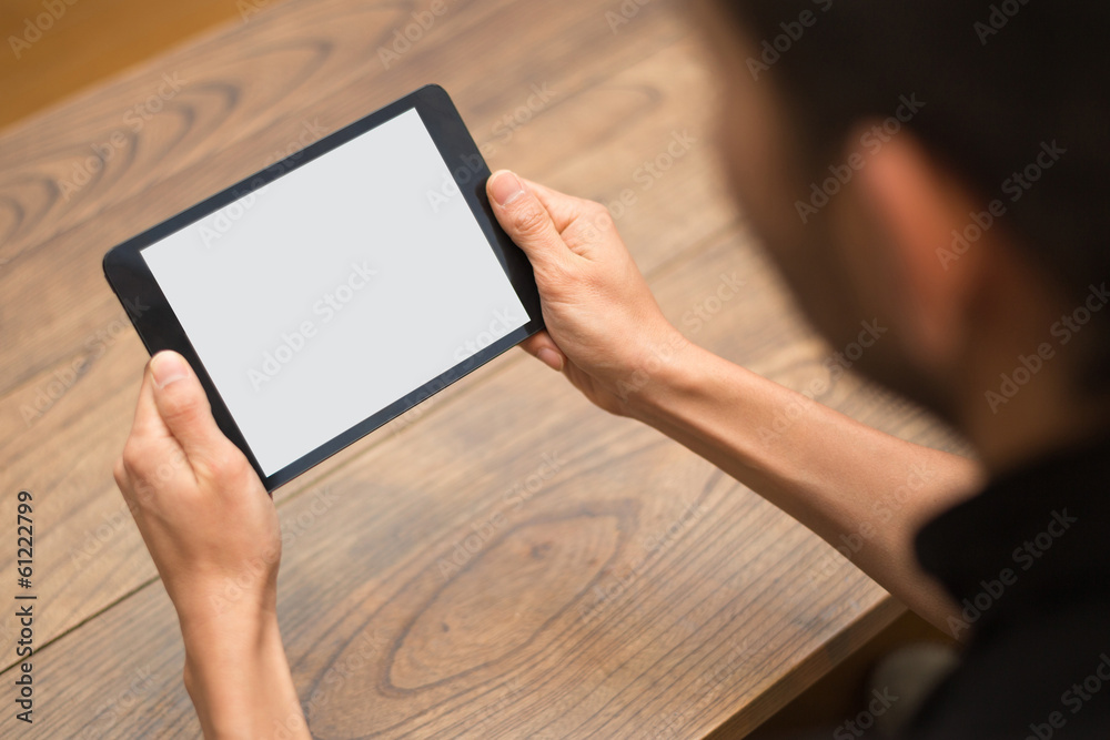 Close-up image of a man using a digital tablet