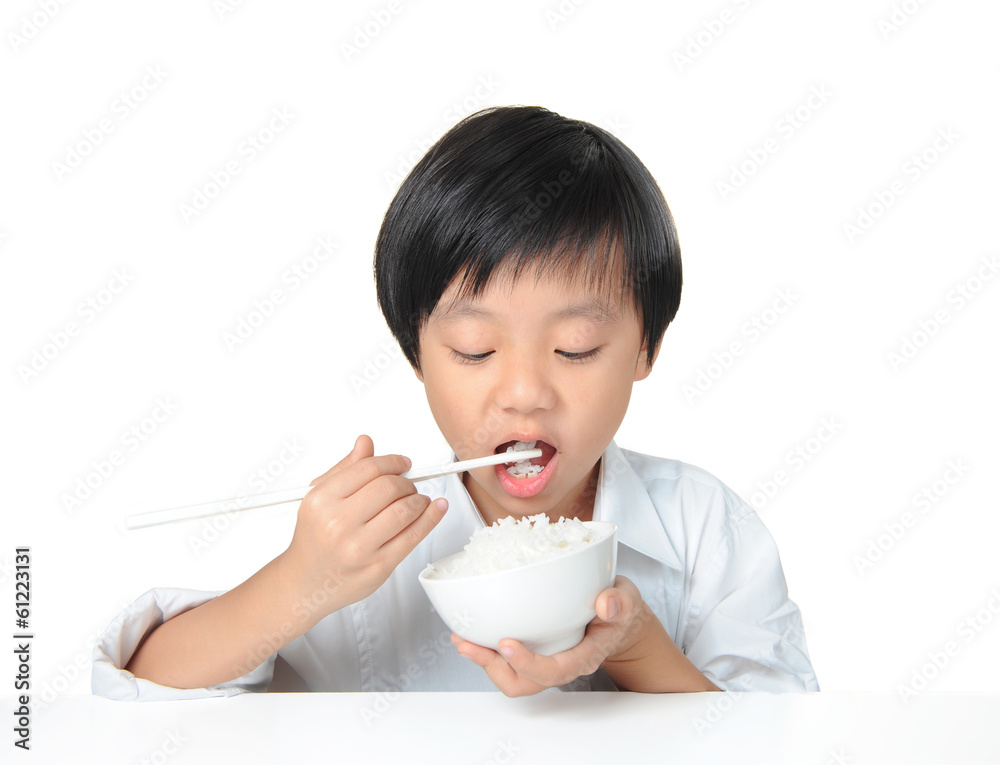 Asian boy eating white rice with chopsticks Asian boy eating white rice with chopsticks