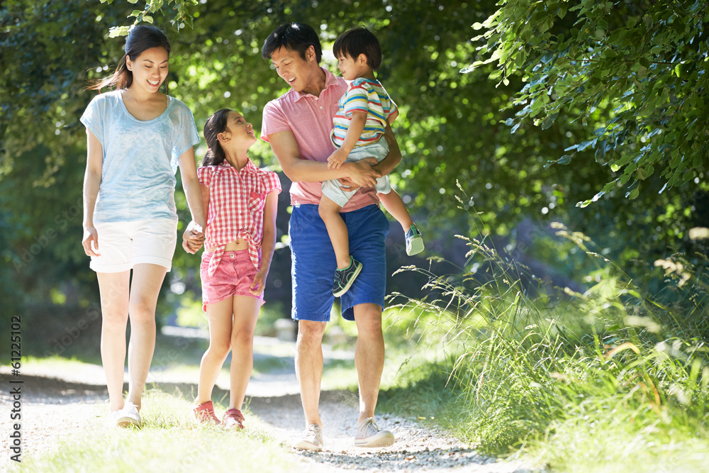 Fototapeta premium Asian Family Enjoying Walk In Countryside