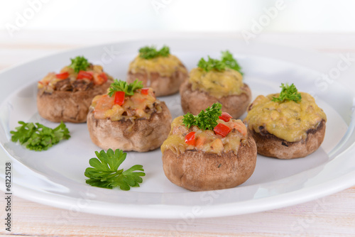 Stuffed mushrooms on plate on table on light background