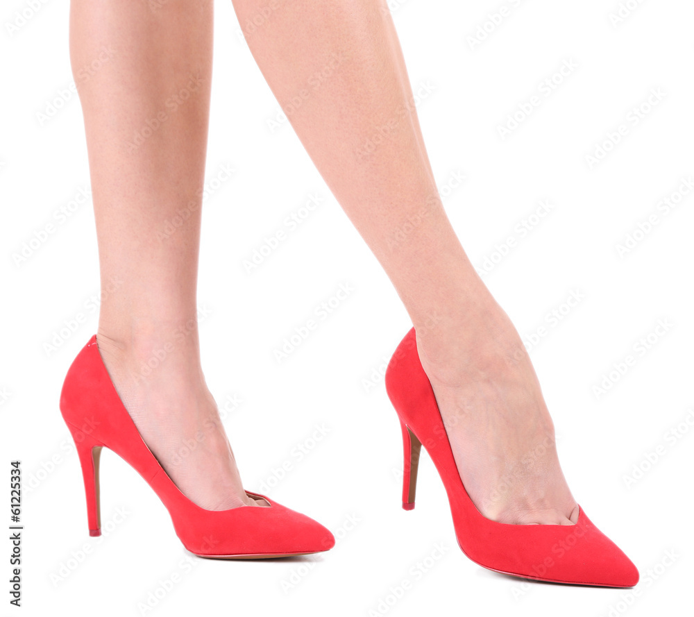 Beautiful female legs in red shoes isolated on white Beautiful female legs in red shoes isolated on white