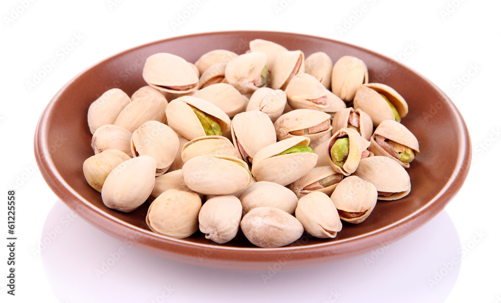 Pistachio nuts on plate isolated on white Pistachio nuts on plate isolated on white
