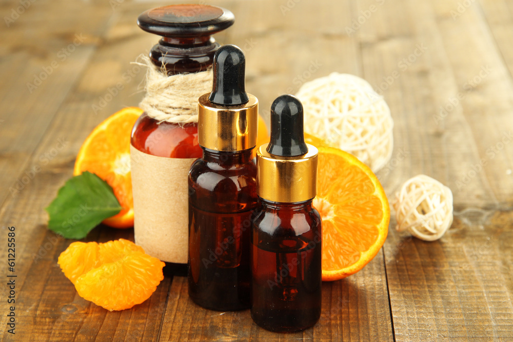 Tangerine essential oil and tangerines on wooden table Tangerine essential oil and tangerines on wooden table