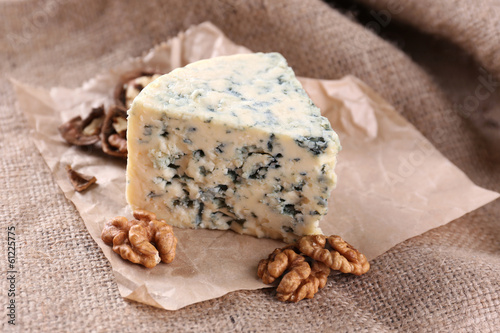 Tasty blue cheese with nuts, on burlap background