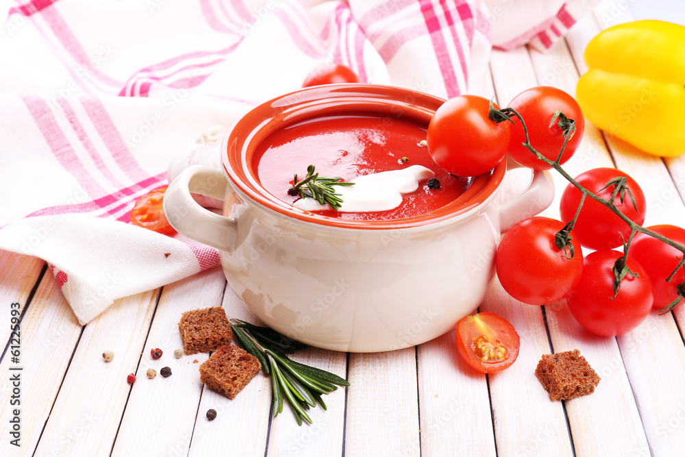 Tasty tomato soup and vegetables on wooden table Tasty tomato soup and vegetables on wooden table