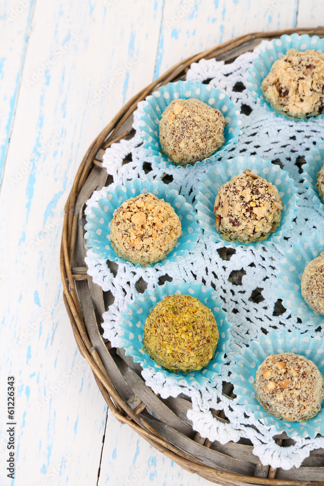 Set of chocolate candies, on wicker mat, on wooden background Set of chocolate candies, on wicker mat, on wooden background