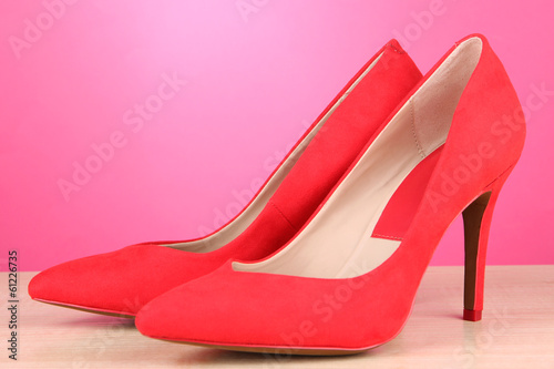 Beautiful red female shoes, on pink background