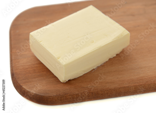 Tasty butter on wooden cutting board isolated on white