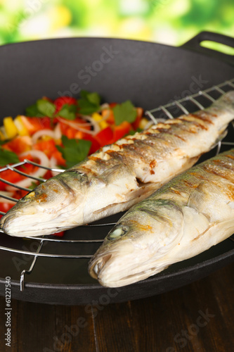 Delicious grilled fish on wok close-up