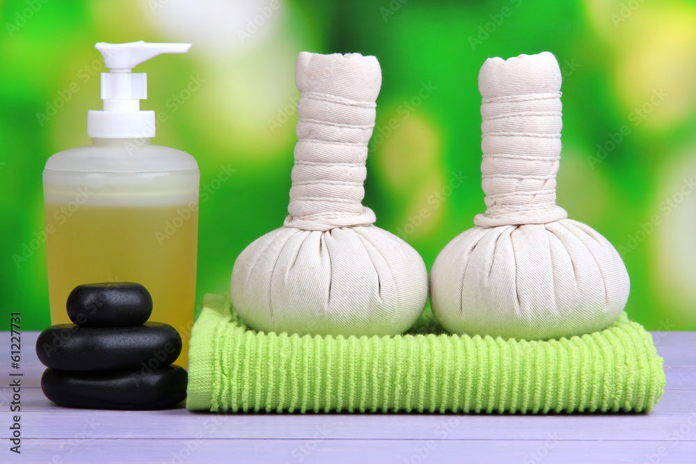 Massage setting on color wooden table, on bright background