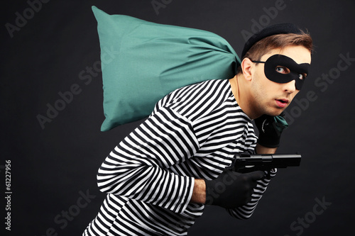 Thief with bag isolated on black