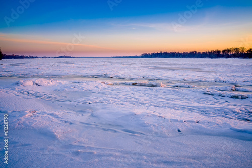 Icy Dnieper River with blue reflections during the sunrise hour