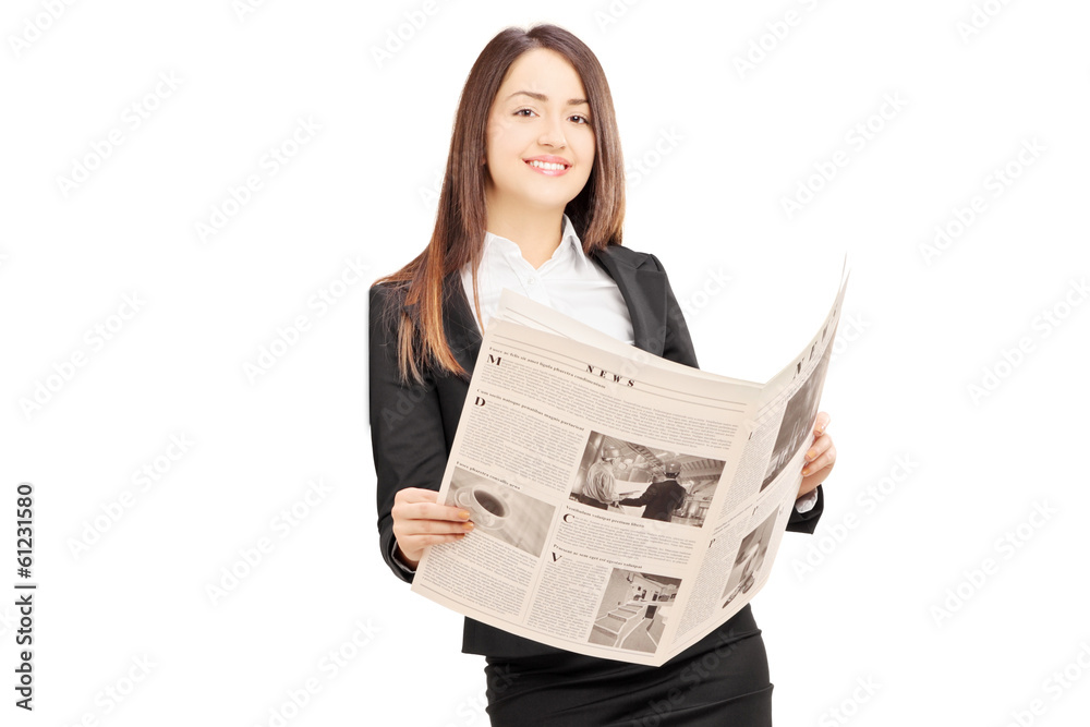 Young businesswoman in suit leaning on wall with a newspaper