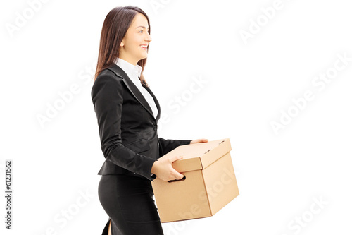Smiling young businesswoman carrying a box