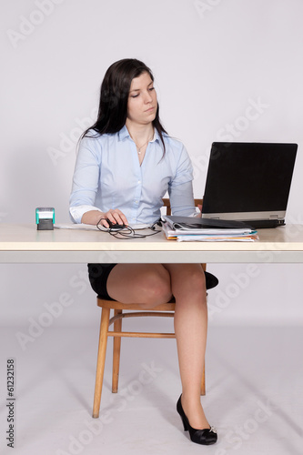 Female poses behind a desk in the office