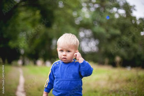 little boy in a tracksuit flees into the forest