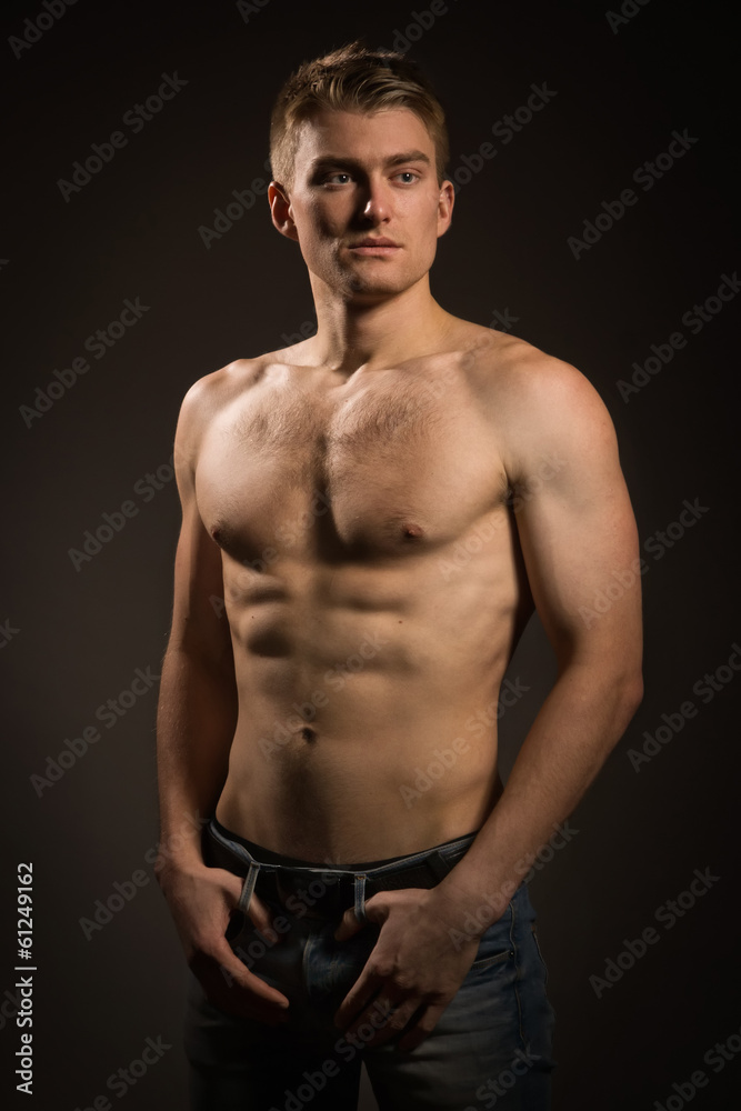 Fototapeta premium Strong athletic man on dark background