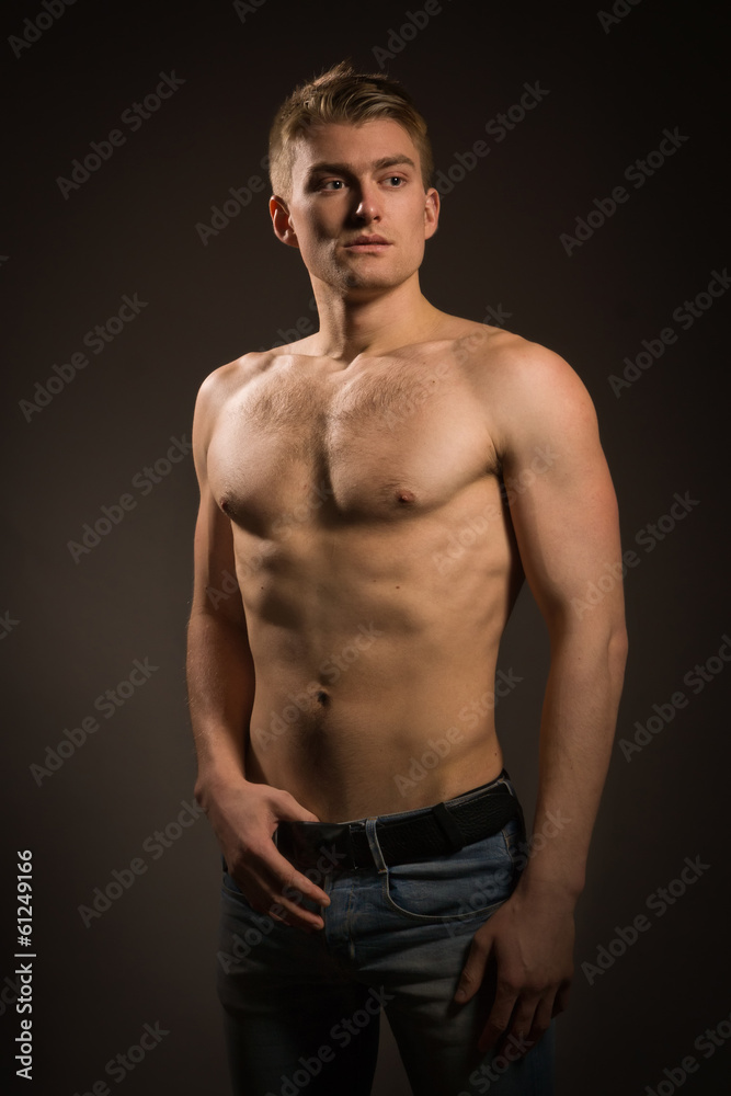Strong athletic man on dark background Strong athletic man on dark background
