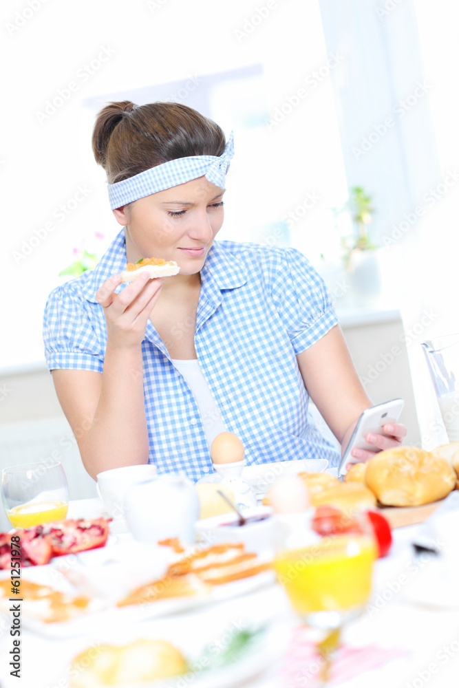 Woman eating breakfast and texting Woman eating breakfast and texting