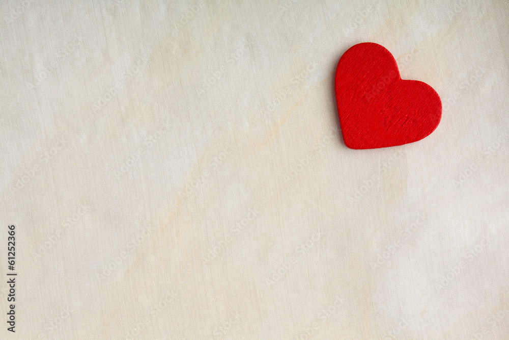 Obraz premium Red wooden decorative heart on white cloth background.