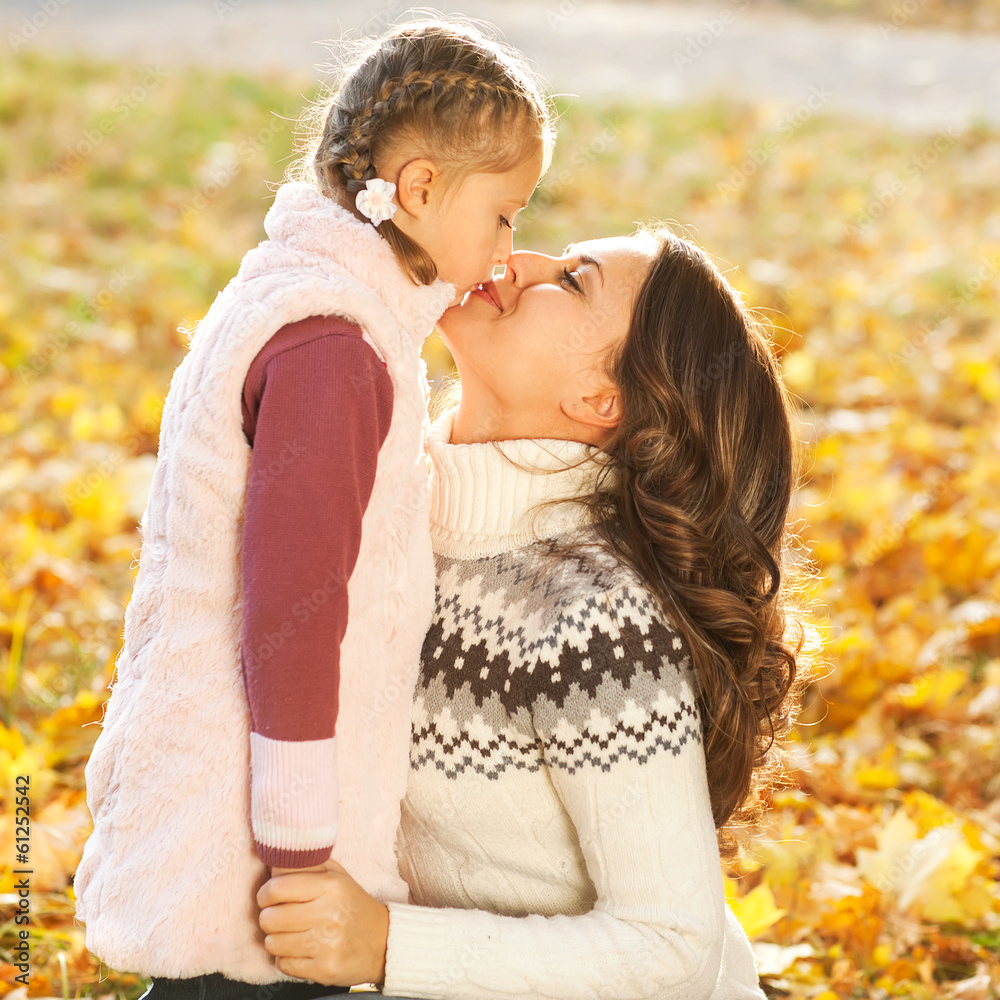 Mother and daughter having fun in the autumn park