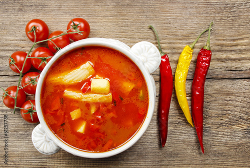 Bowl of tomato soup on wooden table