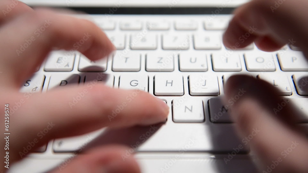 Hands typing text on a laptop keyboard Hands typing text on a laptop keyboard