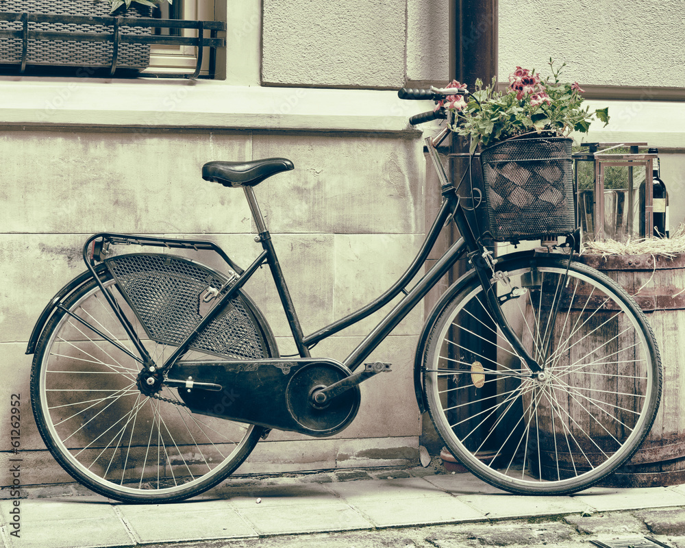 Vintage stylized photo of Old bicycle carrying flowers