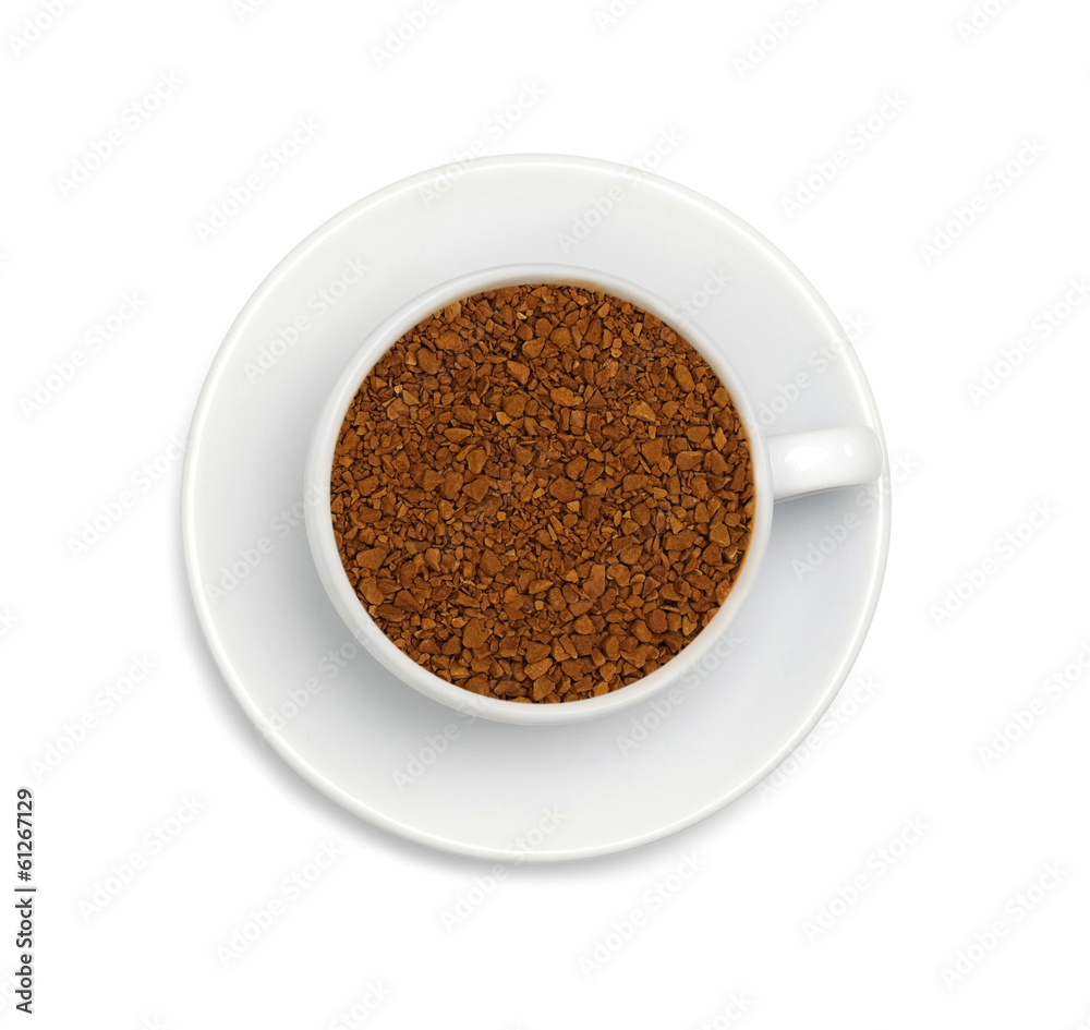 granules of instant coffee in a white cup and saucer isolated on granules of instant coffee in a white cup and saucer isolated on