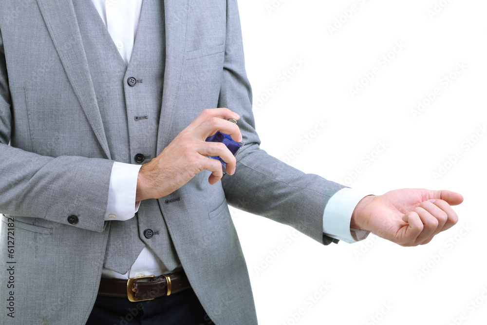 Obraz premium Handsome young man using perfume isolated on white