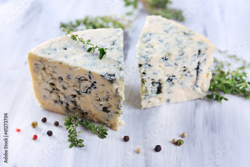 Tasty blue cheese with thyme and spices on wooden table