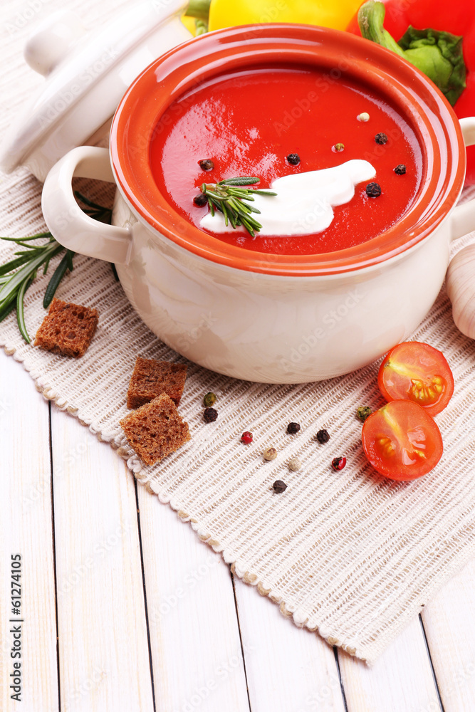 Tasty tomato soup and vegetables on wooden table