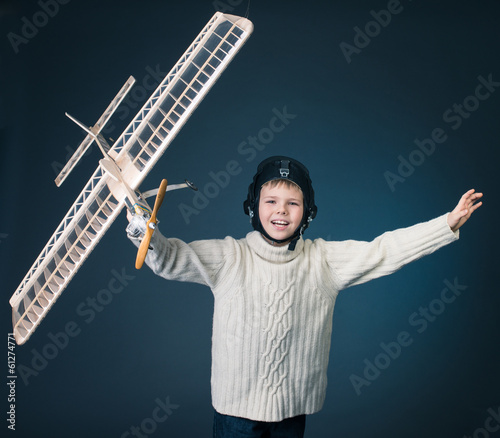 Happy boy playing with a model plane. Dream.