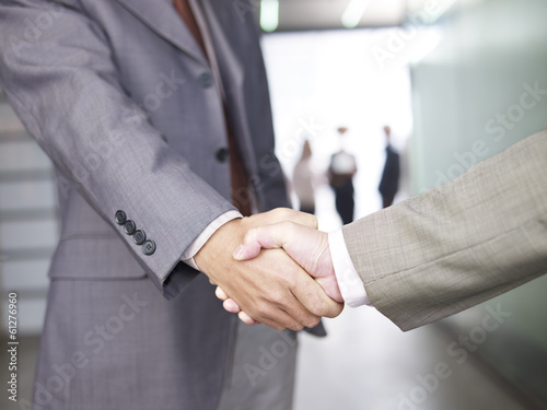 businesspeople shaking hands in office photo
