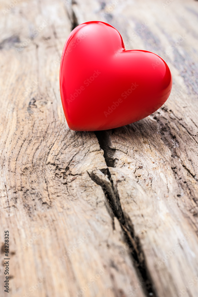 Fototapeta premium Red heart in crack of wooden plank