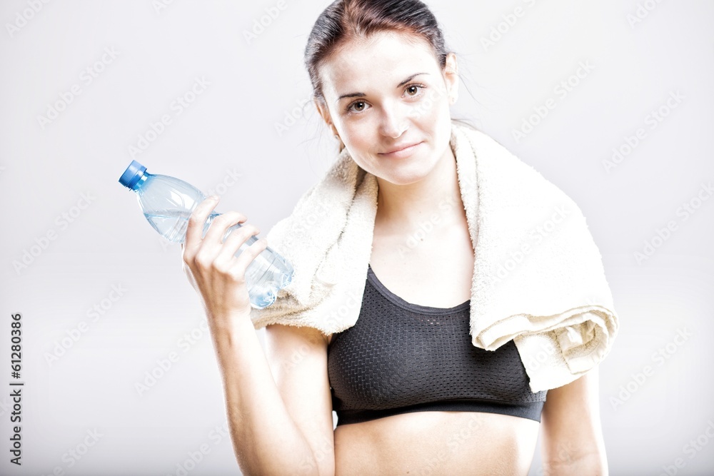 Tired woman after fitness with water bottle and towel Tired woman after fitness with water bottle and towel