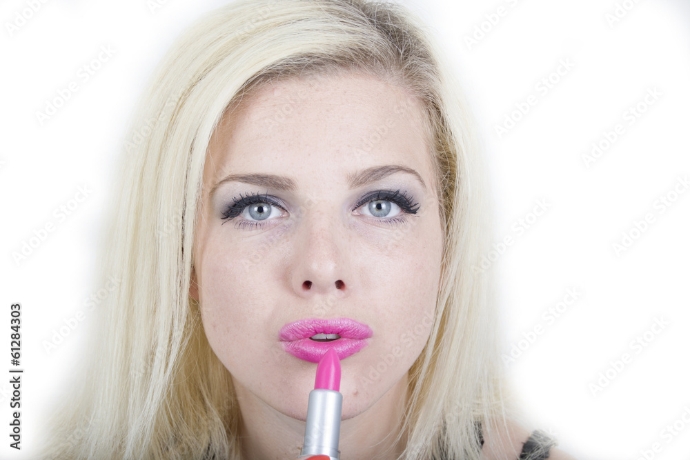 Young blonde woman putting on some make-up Young blonde woman putting on some make-up