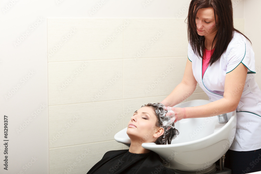Fototapeta premium Hairstylist washing woman hair. Hairdressing beauty salon
