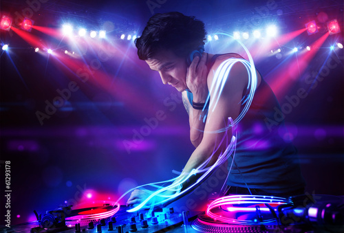 Disc jockey playing music with light beam effects on stage © ra2 studio
