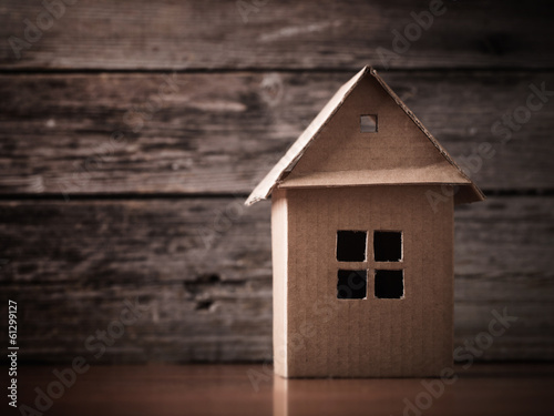 house in brown recycled paper on wooden background